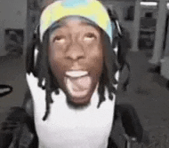 a man wearing headphones and a headband is sitting in a chair with his mouth open .