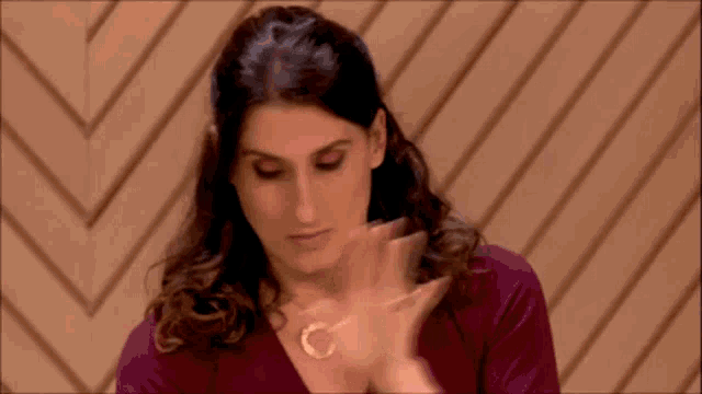 a woman wearing a necklace with a letter c on it