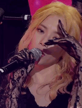 a close up of a woman singing into a microphone