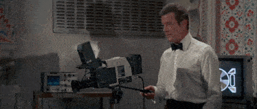 a man in a white shirt is holding a camera with the word sony on it