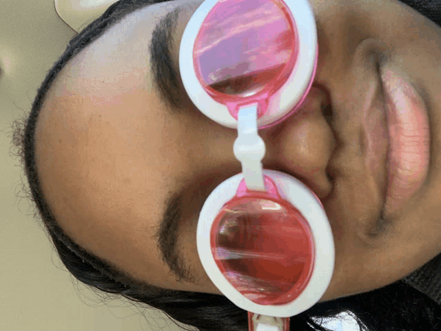 a woman wearing a pair of pink and white glasses
