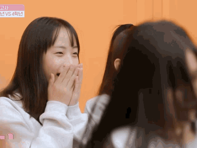 a girl covering her mouth with her hands and a sign that says ' vs 4 ' on it