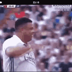 a man in a white shirt with the word fly emirates on it is standing in front of a crowd of people .