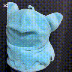 a close up of a blue stuffed animal on a black surface .