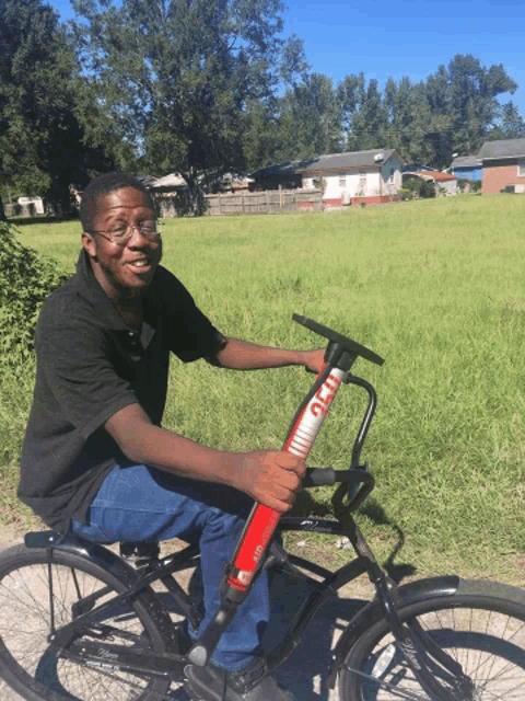 a man riding a bike with a red pump that says gmt on the handlebars