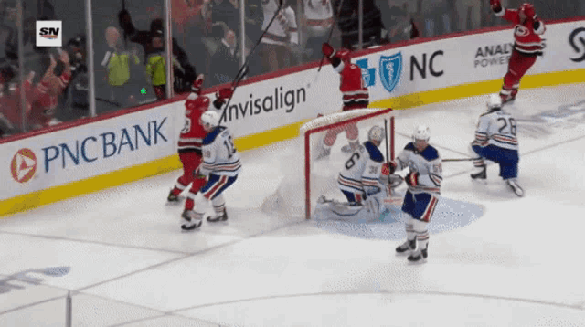 a hockey game is being played in front of a pnc bank advertisement