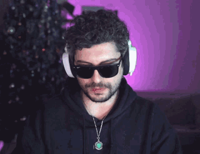 a man wearing sunglasses and headphones looks at the camera