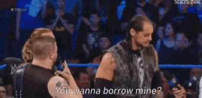 a group of wrestlers are standing in a wrestling ring and one of them is asking if they wanna borrow mine .