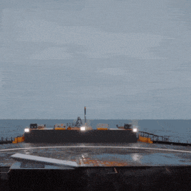 a large ship is in the middle of the ocean with a few lights on the side