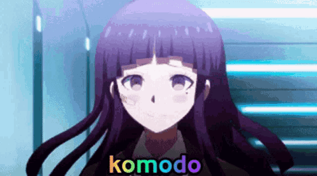 a purple haired anime girl is standing in a hallway with komodo written on her face .