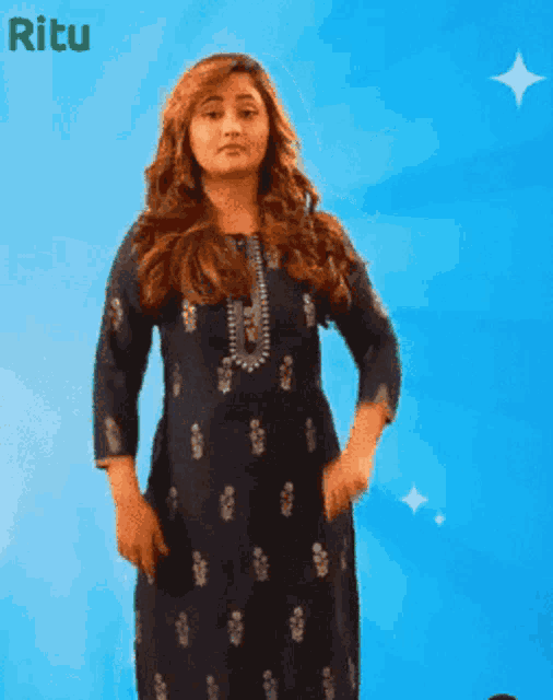 a woman in a blue dress stands in front of a blue background with the word ritu written on it