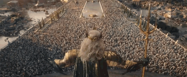 a man with a trident stands in front of a crowd of people