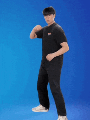 a man in a black t-shirt with the letter s on it is standing in front of a blue background