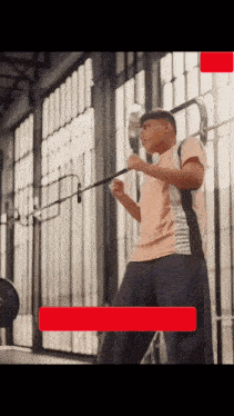 a man is holding a barbell in a gym