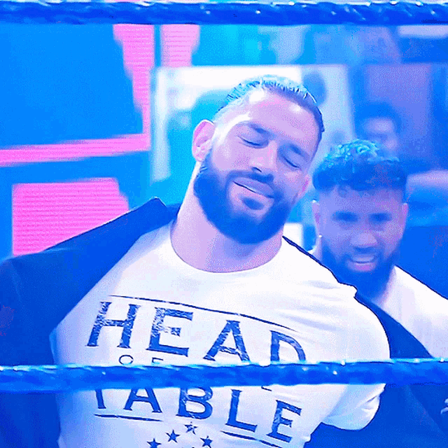 a man with a beard is wearing a white shirt that says head table