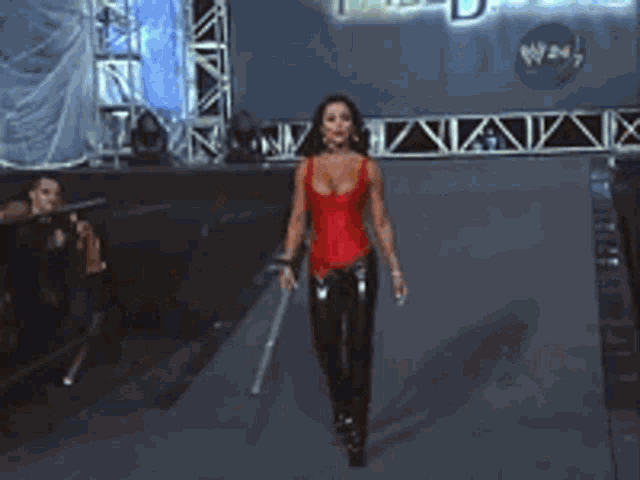 a woman in a red top is holding a sword in front of a sign that says fallout