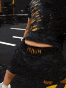 a woman wearing ufc shorts squatting down