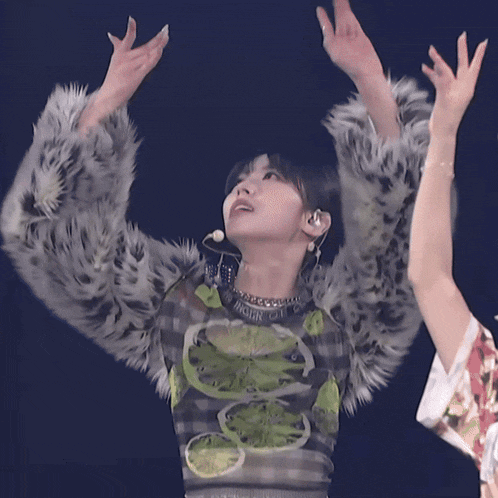 a woman wearing a fur coat and a necklace that says high on it