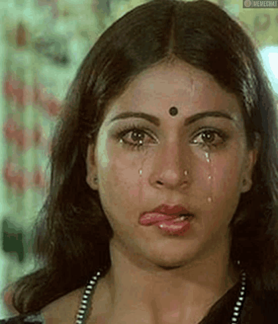a close up of a woman 's face with tears coming out of her eyes .