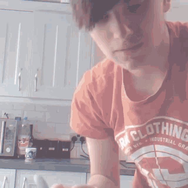 a person wearing an orange shirt that says rk clothing industrial