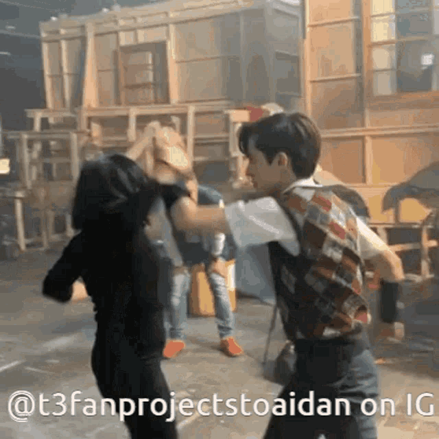 a man and a woman are standing next to each other and fighting .