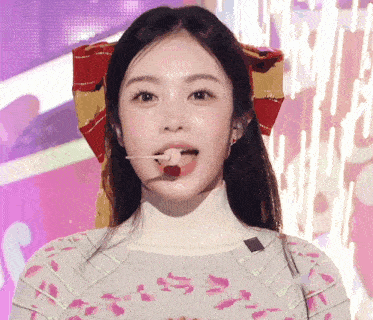 a close up of a woman 's face with a red bow on her head