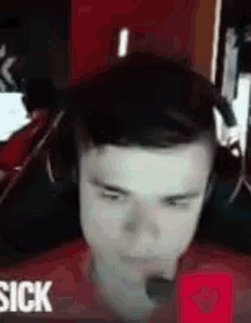 a young man wearing headphones and a microphone is sitting in front of a computer .