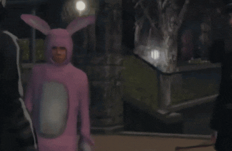 a man in a pink bunny costume is standing next to a man in a black suit