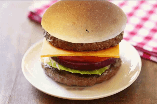 a hamburger with cheese lettuce and tomato on a plate