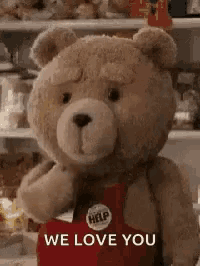 a teddy bear wearing a red apron is standing in front of a refrigerator .