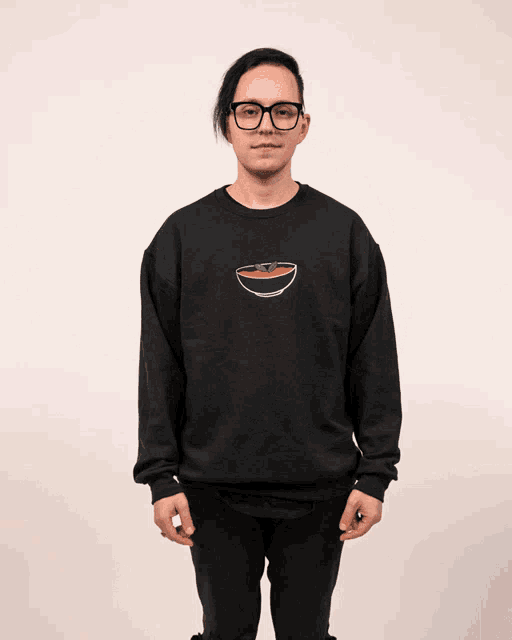 a man wearing glasses and a black sweatshirt with a bowl on it