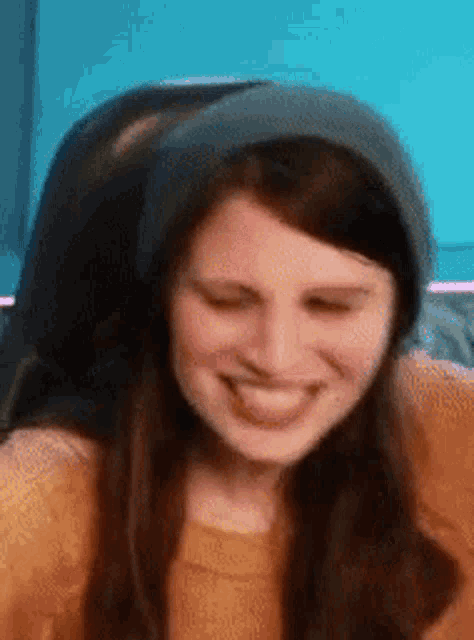 a close up of a woman wearing a beanie and smiling