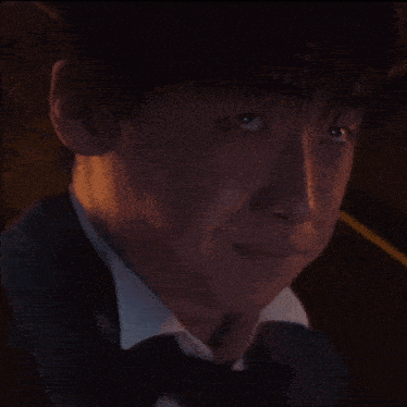 a man in a tuxedo and bow tie looks up at something