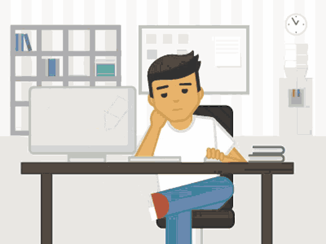 a man sits at a desk with his head resting on his hand in front of a computer monitor
