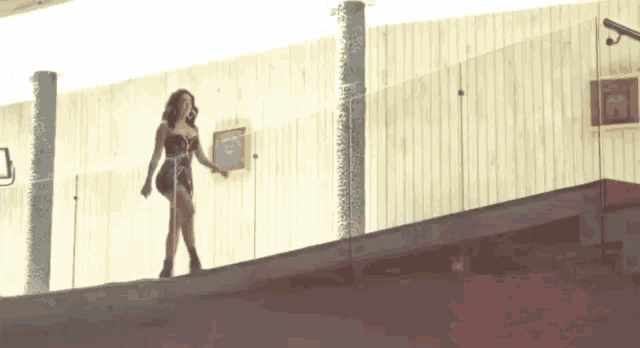 a woman in a superhero costume is standing on a balcony