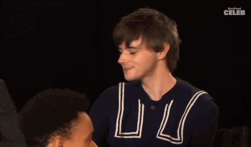 a man in a blue shirt with the letter l on it is laughing