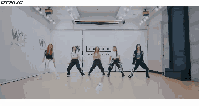 a group of women are dancing in front of a sign that says wne