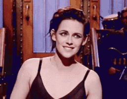 a woman in a black bra is smiling in front of a drummer