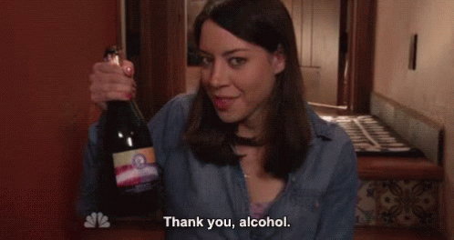 April Ludgate holding a bottle of wine and saying 'Thank you, alcohol'
