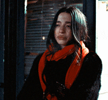 a woman wearing a scarf and a fur coat smoking a cigarette