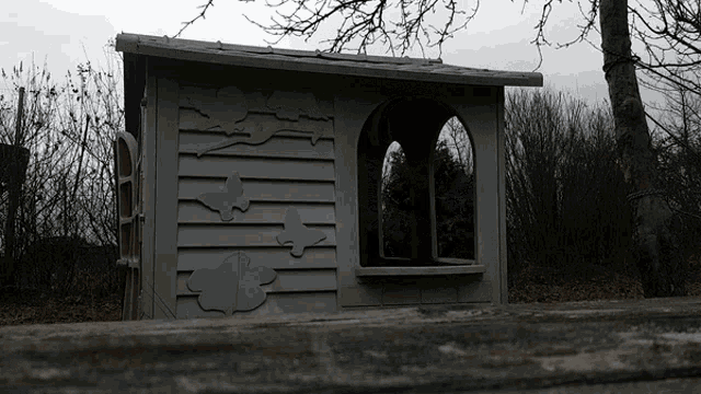 a small house with a window and a few birds on the side