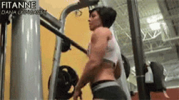 a woman is doing exercises on a machine in a gym with the name fitanne on the bottom of the screen .