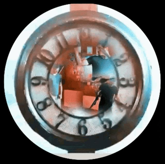a clock with a reflection of a man in the middle of it