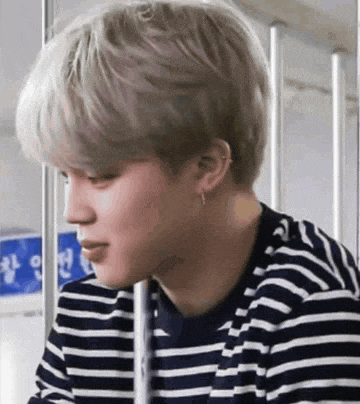 a close up of a person wearing a striped shirt and earring .