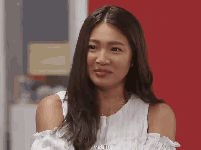 a woman wearing a white off the shoulder top with the word maddiee on the bottom