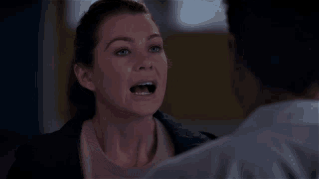 a woman screams at a man in a grey shirt
