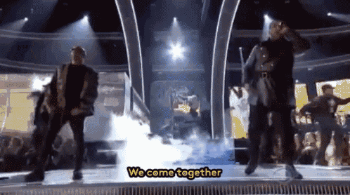 a group of men are dancing on a stage with the words we come together written below them