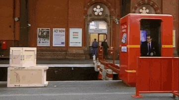a red booth in front of a building that says act now on it