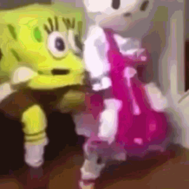 spongebob and hello kitty are standing next to each other and looking at each other .