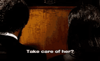 a man and a woman are standing in front of a wooden door and the man says take care of her